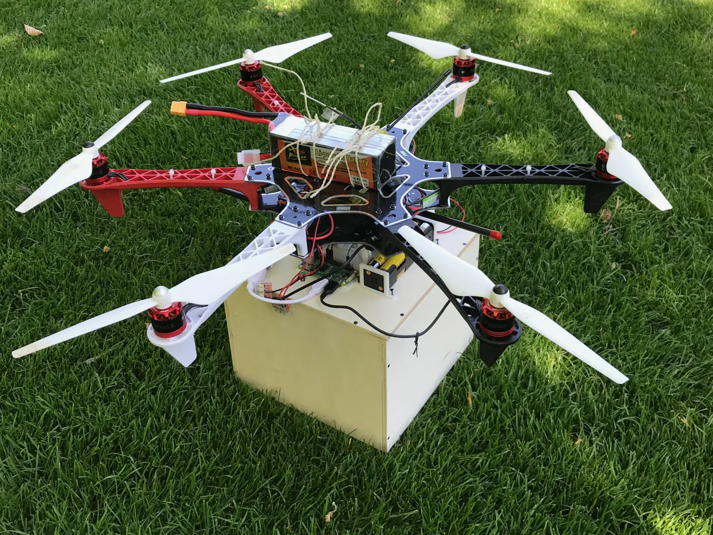 v1 — wooden box, fishing line, Raspberry Pi. Too heavy to fly well, too slow to be useful.