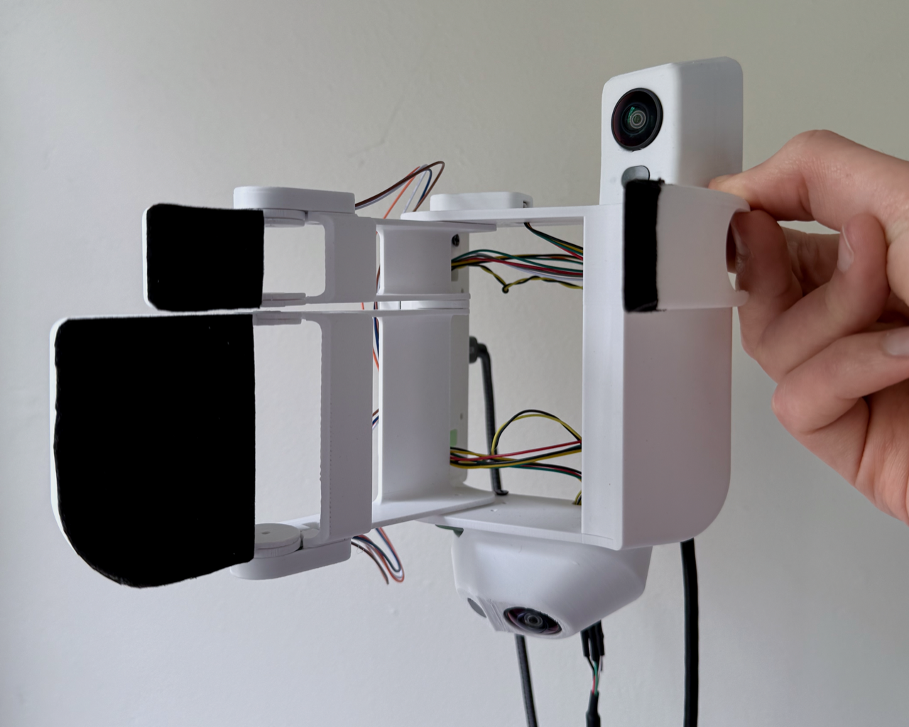 V3 glove. Custom DAQ board on the back of the wrist; four MLX90393 Hall sensors at the joints. (The on-glove cameras are from an earlier stereo build; production pose tracking uses an externally-mounted GoPro.)